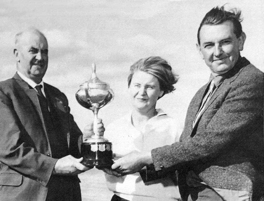 Mr A.F. Saunders (left) from the Soil Conservation Authority presents the Hanslow Cup for Soil Conservation in the Otway District to Helen and Geoff Henderson at their property Inverness at St Leonards in 1968. They are standing in front of a large, recently constructed dam on the property.