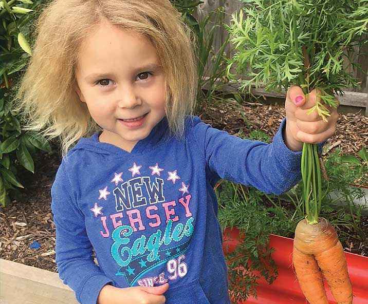Lisa Wangman’s daughter Tayla with the first carrots she planted and grew. 